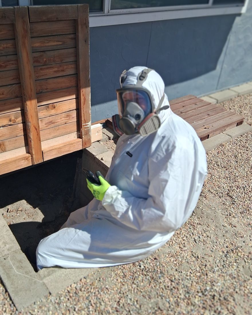 CJ Bourne in protective gear at a crawlspace access, ready to inspect